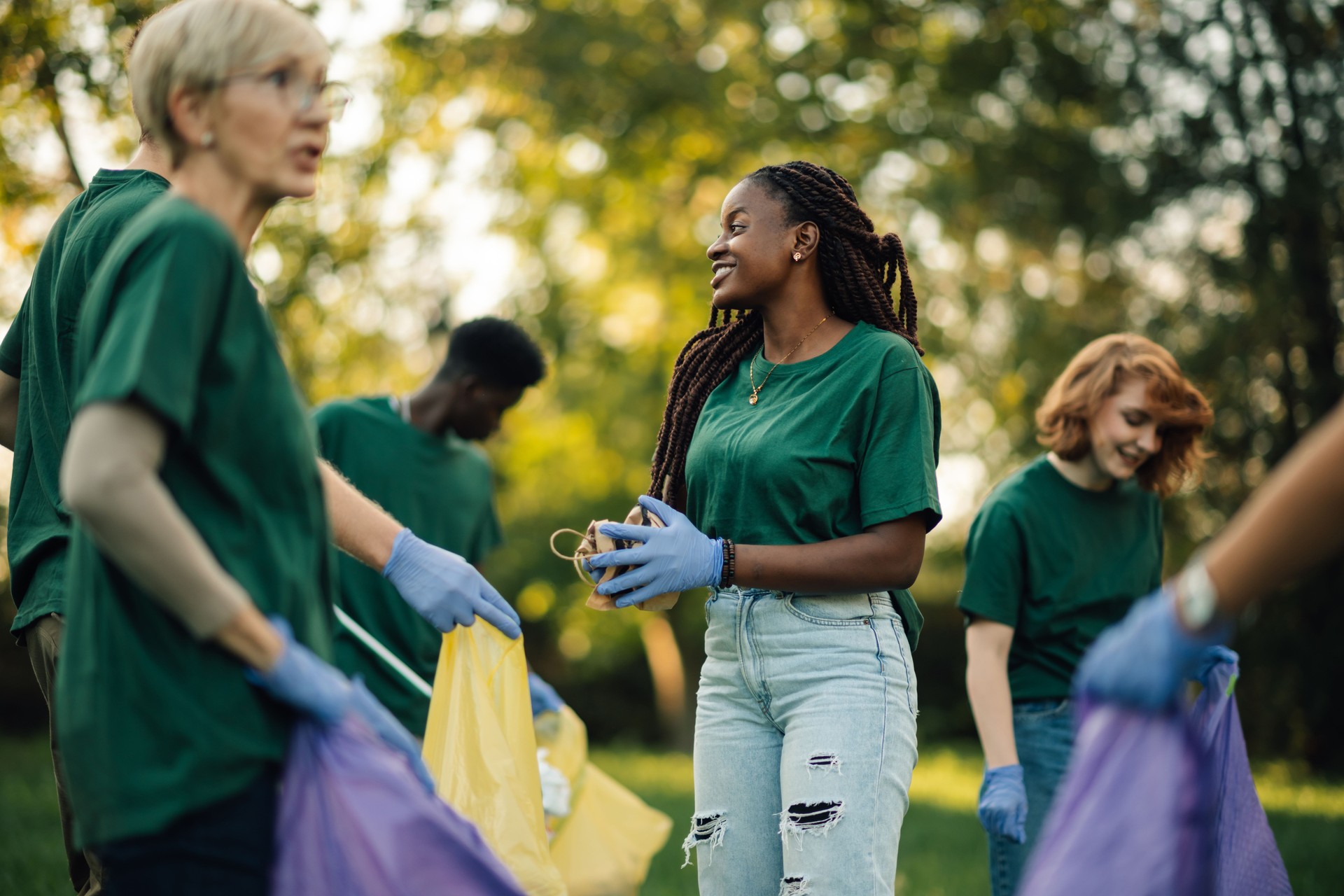 Volunteers collecting trash in park during community cleanup
